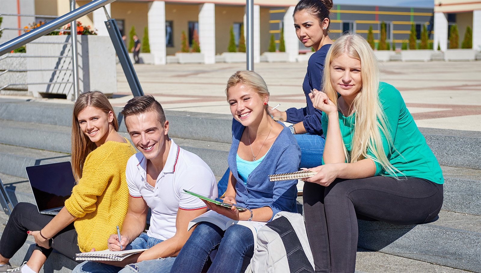 Group of high schools students studying, sitting on outside steps